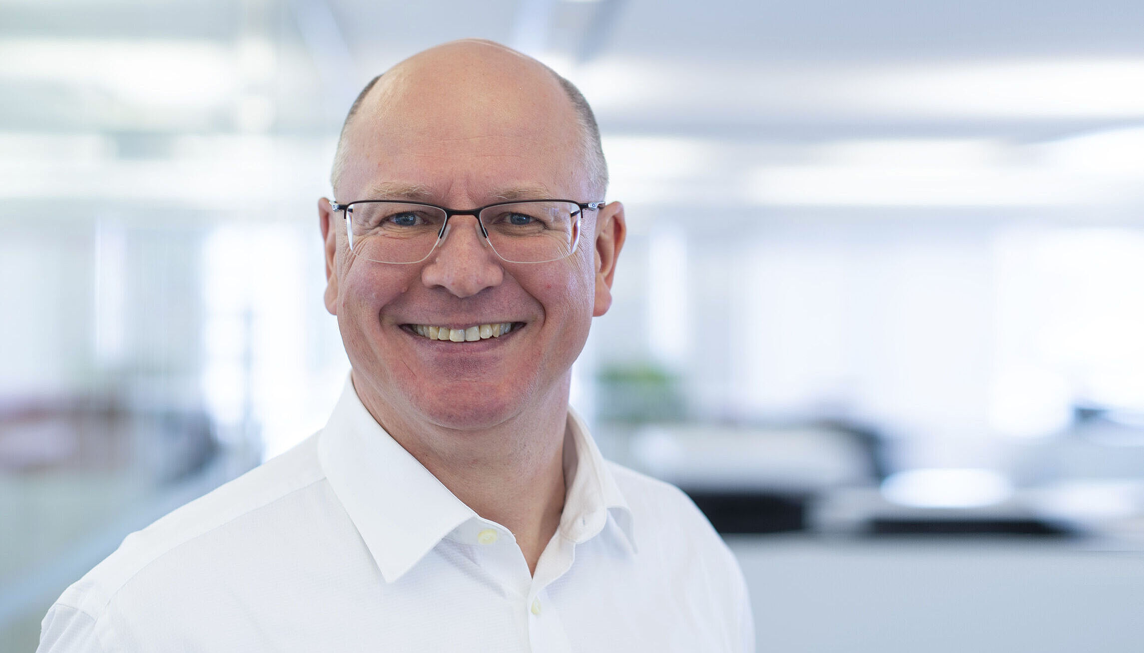 Smiling man in a white shirt.