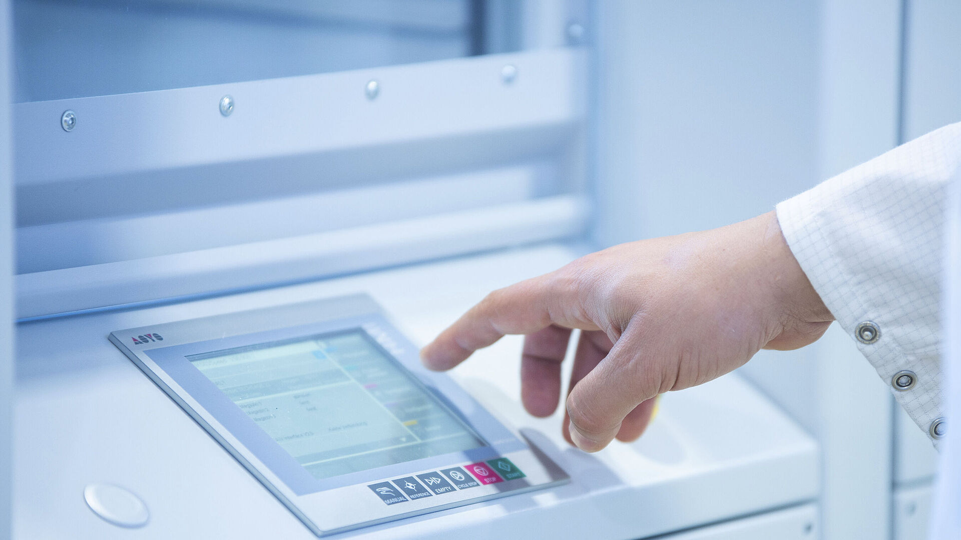 Hand tippt auf ein Bedienpanel