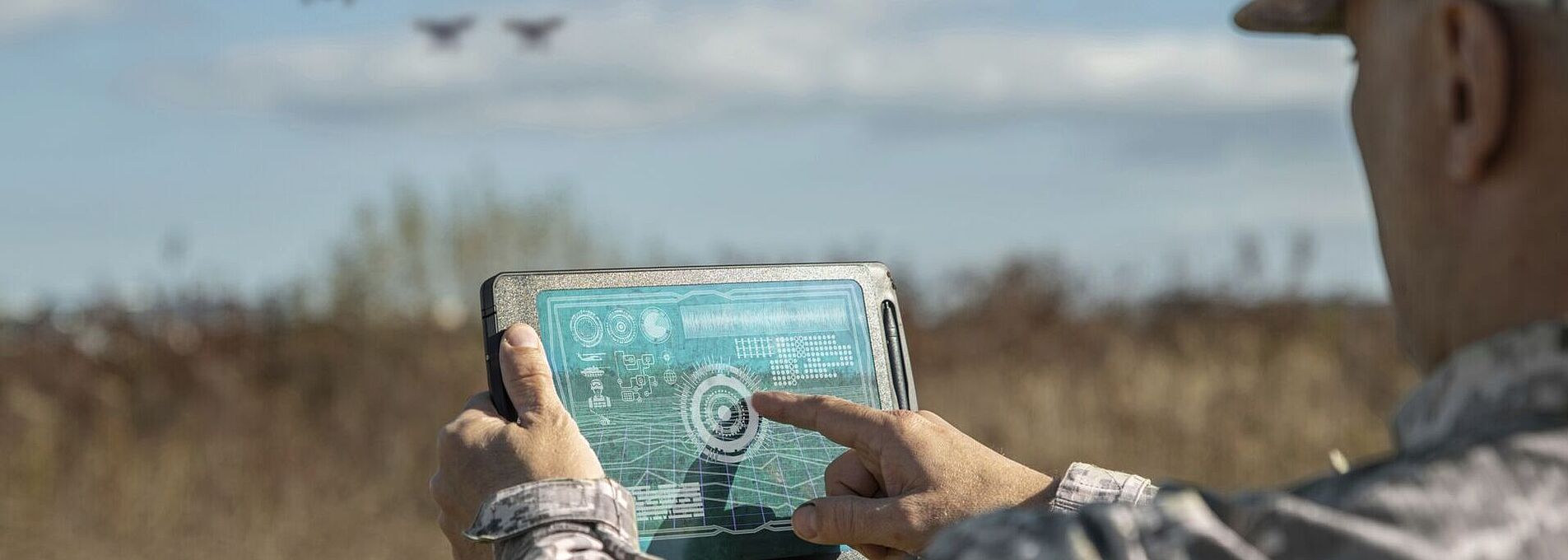 Kriegsanalytiker kontrollieren die Koordination des Militärteams mit Drohnen. Militärischer Befehlshaber mit einem digitalen Tablet-Gerät mit erweiterten Realitätstruppen im Freien.