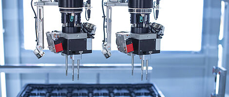 Interior view of an assembly machine featuring a dual gripper handling components with precision.