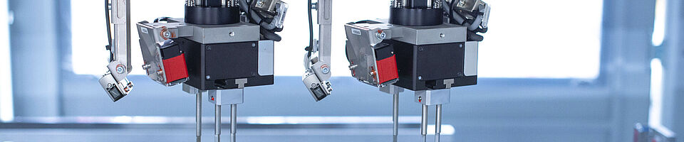 Interior view of an assembly machine featuring a dual gripper handling components with precision.