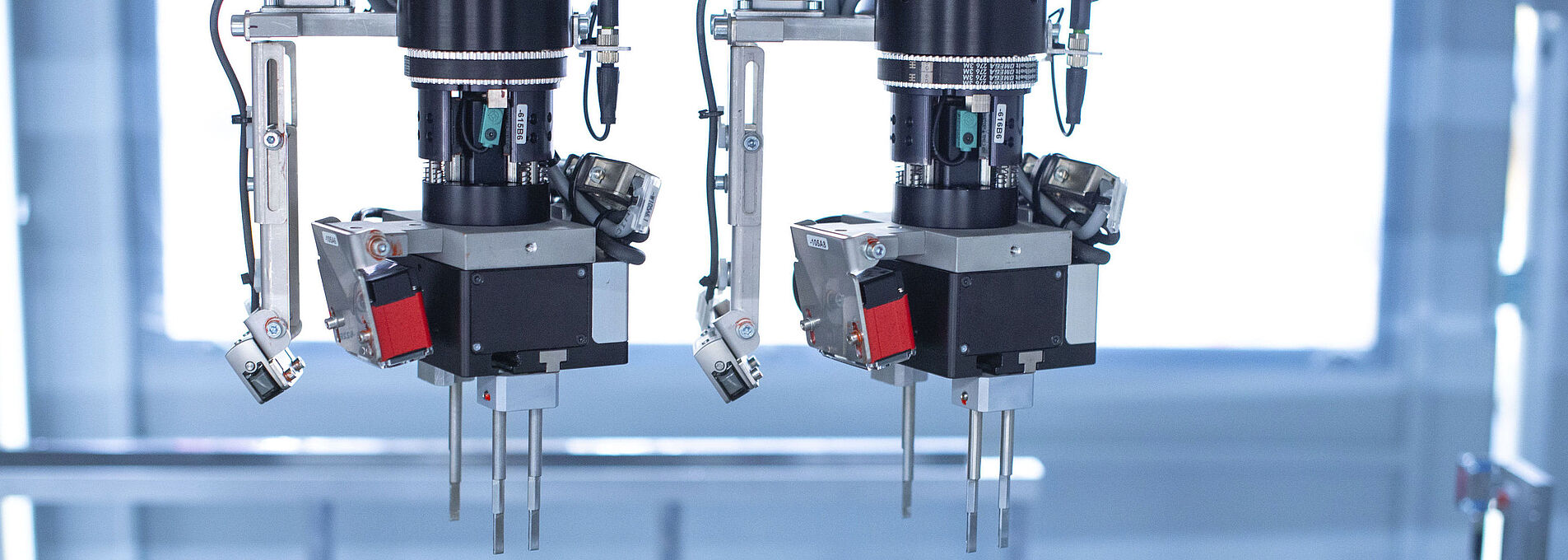 Interior view of an assembly machine featuring a dual gripper handling components with precision.