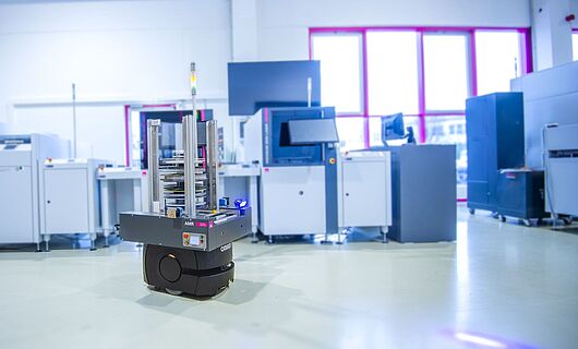 ASYS MatLog AMR Reel Container mit SMD Linie im Hintergrund