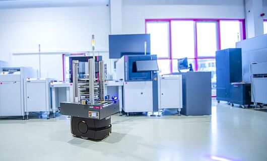 ASYS MatLog AMR Reel Container mit SMD Linie im Hintergrund