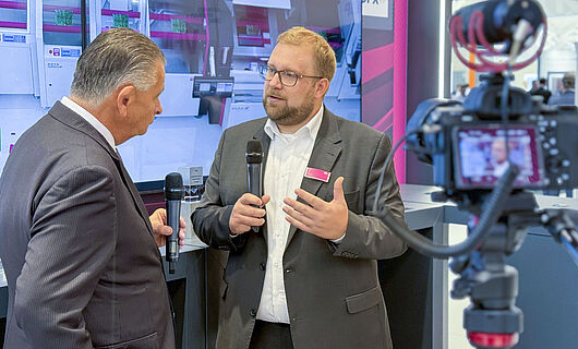 Zwei Männer in einem Interview vor laufender Kamera