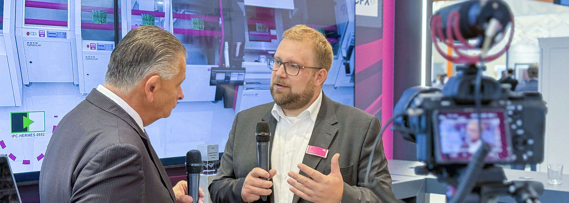 Zwei Männer in einem Interview vor laufender Kamera