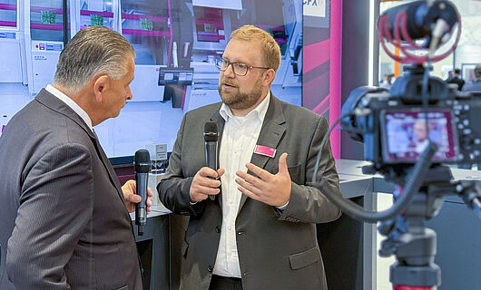 Zwei Männer in einem Interview vor laufender Kamera