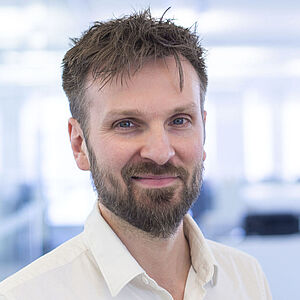 Smiling man in a white shirt.