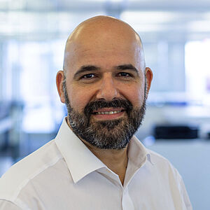 Smiling man in a white shirt. In a well-lit office.
