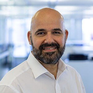 Smiling man in a white shirt. In a well-lit office.