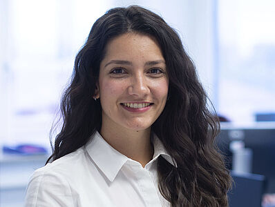 A smiling woman standing in an office.