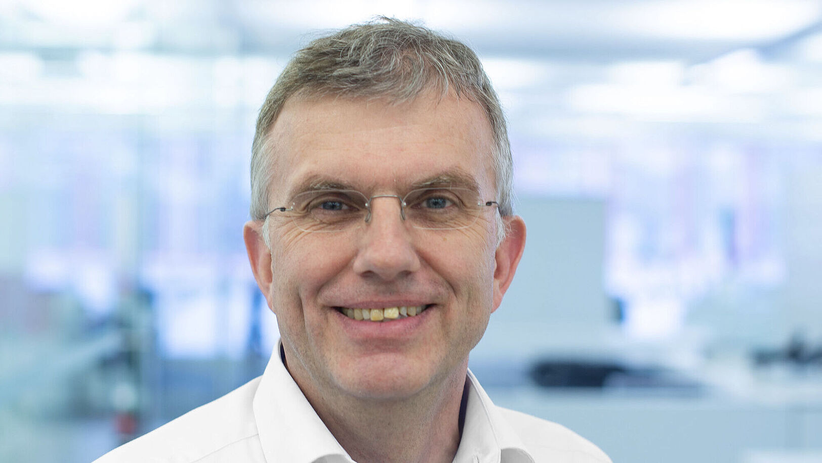Smiling man in a white shirt.