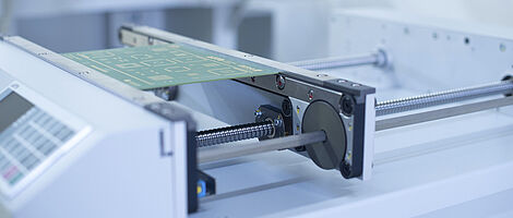 Close-up of a handling transport machine with an inserted circuit board.