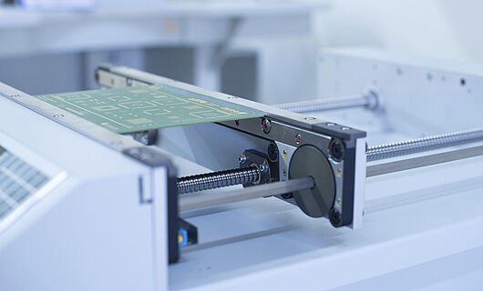 Close-up of a handling transport machine with an inserted circuit board.