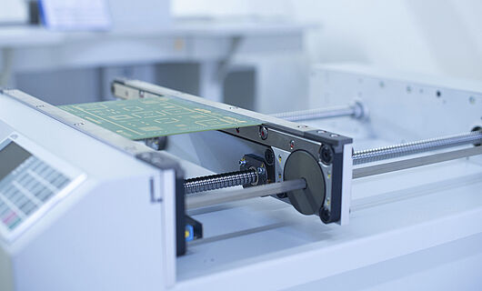 Close-up of a handling transport machine with an inserted circuit board.