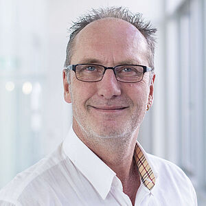 Smiling man in a white shirt.