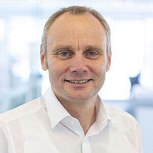 Smiling man in a white shirt.