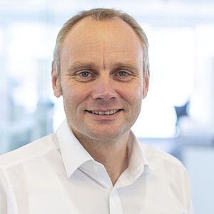 Smiling man in a white shirt.