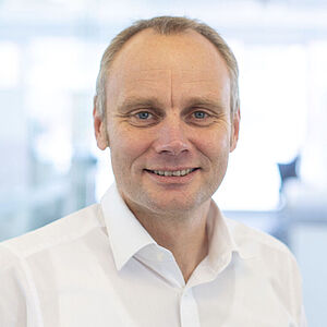 Smiling man in a white shirt.