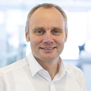 Smiling man in a white shirt.