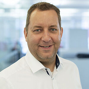 Smiling man in a white shirt.