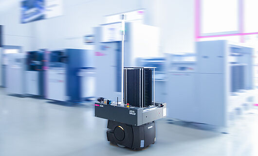 AMR in einem Demoraum vor einer Maschinenlinie.