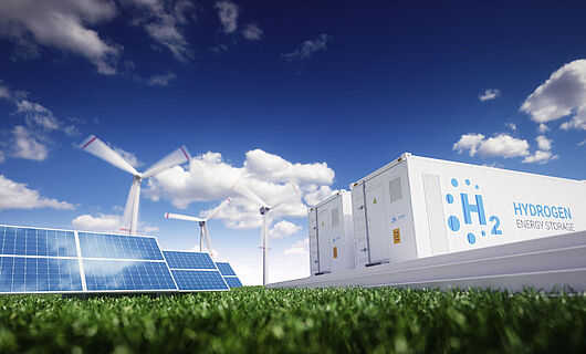 Solar panels, wind turbines, and hydrogen energy storage under blue skies